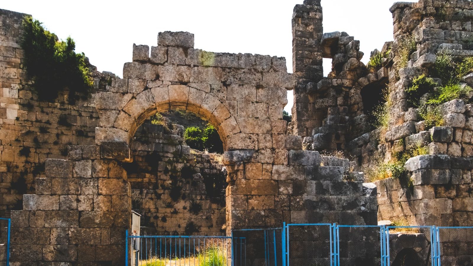 Ancient stone archway framing a path into morning light